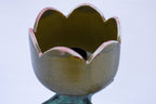 Ceramic flower-shaped vase with a textured surface on a white background
