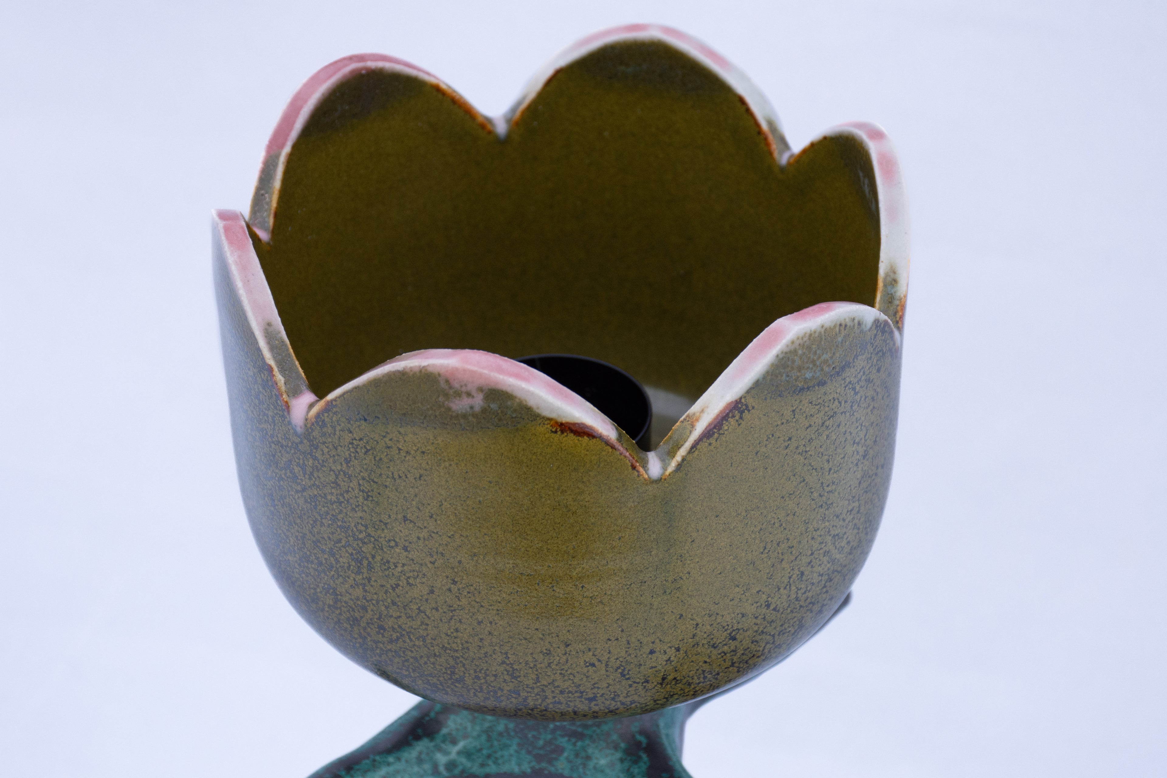 Ceramic flower-shaped vase with a textured surface on a white background